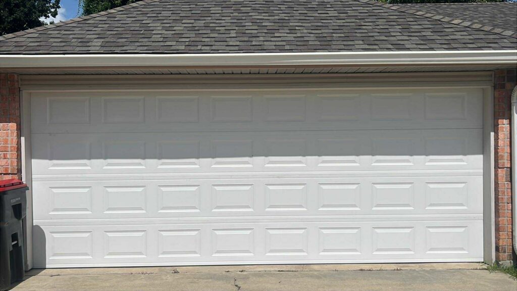 A wide white panel garage door on a brick house, installed by Legacy Garage Doors & Repairs in Church Point, LA.