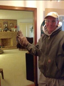 A Perdue Exterminators technician holding a small owl, demonstrating wildlife removal services in Roanoke, VA.