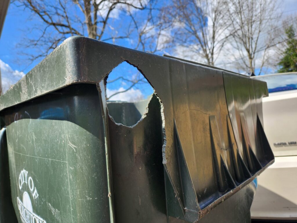 A trash can with a large hole, showing damage caused by wildlife, addressed by S-Tier Wildlife Control LLC in Lexington, KY.