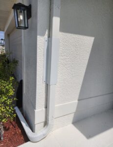 A white wildlife exclusion device installed on a downspout of a house by The Wildlife Whisperer Inc in Cape Coral, FL