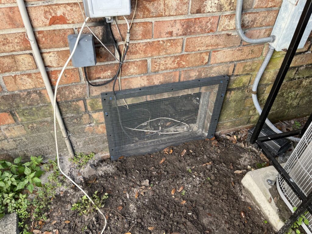 A metal mesh installed over a crawl space opening for wildlife exclusion by Crawford Pest Control in Jacksonville, FL.