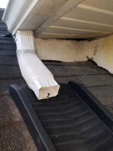 A wildlife exclusion ramp installed on a roof near a downspout, showing an animal exit point by The Wildlife Whisperer Inc in Cape Coral, FL