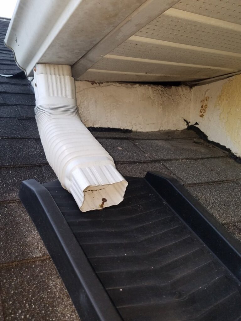A wildlife exclusion ramp installed on a roof near a downspout, showing an animal exit point by The Wildlife Whisperer Inc in Cape Coral, FL