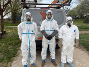 Wildlife and pest control technicians in full PPE standing by their van, ready for a job by Critter Mitch in Shawnee, KS.