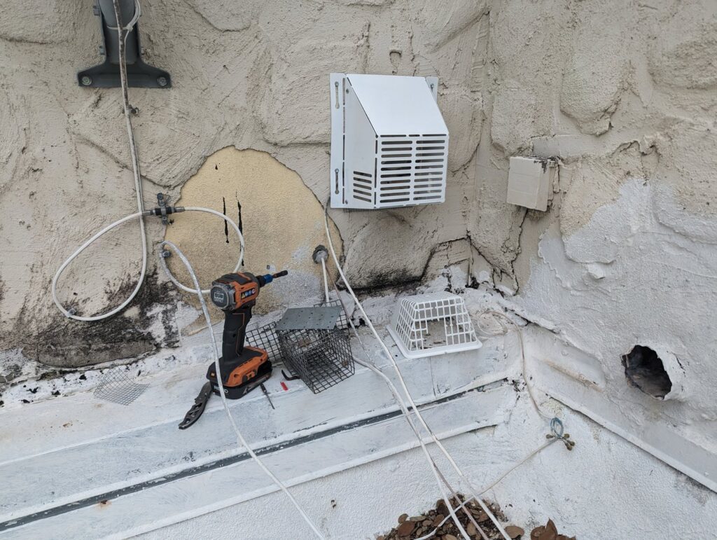 Various wildlife traps, exclusion vents, and tools on a roof ledge, used by The Wildlife Whisperer Inc for pest control in Cape Coral, FL