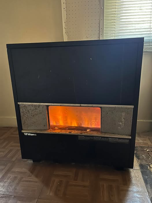 A Williams brand wall heater or furnace with visible flames, showcasing a heating unit serviced by Greenley Heating & Cooling in Waterloo, IA