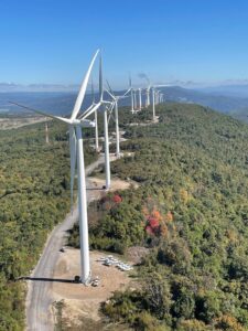 A row of large wind turbines on a mountain ridge, representing a renewable energy project by IBEW Local 24 in Baltimore, MD.