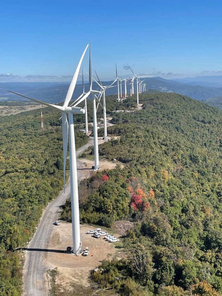 A row of large wind turbines on a mountain ridge, representing a renewable energy project by IBEW Local 24 in Baltimore, MD.