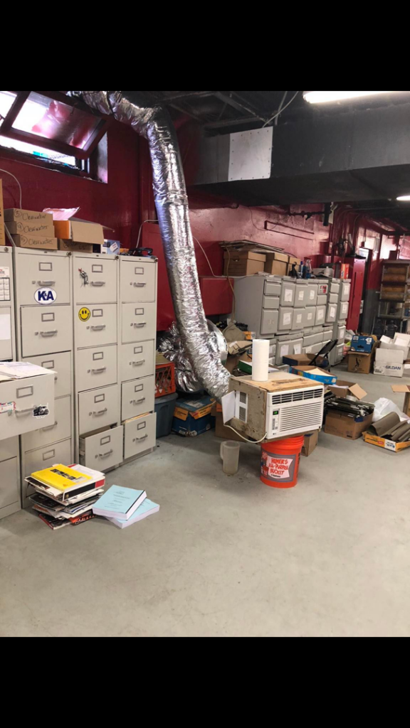 A window AC unit connected to flexible ductwork in a commercial space, handled by Iconic HVAC Solutions in Philadelphia, PA.