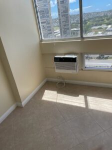 A window AC unit installed high on a wall, demonstrating installation services by Ultimate Air Conditioning in Pearl City, HI
