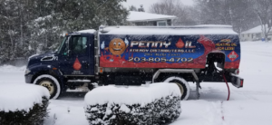 A Penny Oil Energy Distributors LLC truck making a heating oil delivery in the snow in Waterbury, CT.
