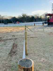 Close-up of a wire fence post installation by Smith Land and Farm in Mansfield, GA