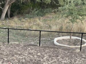 A simple wire mesh fence installed in a residential backyard by Superior Fence Co. of San Antonio, TX.