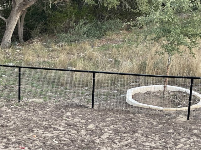 A simple wire mesh fence installed in a residential backyard by Superior Fence Co. of San Antonio, TX.