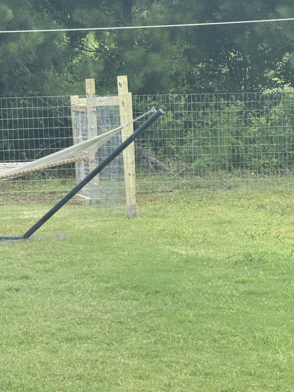 A sturdy wire mesh fence with wooden posts defining a backyard boundary, installed by G2 Home Solutions in Phenix City, AL.