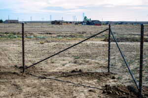 A wire mesh fence being installed in an open field by Fence Tech in Everett, WA, for property demarcation.