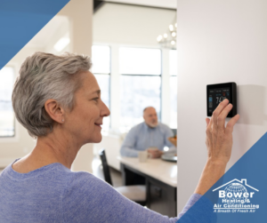 A woman adjusting a smart thermostat for optimal home comfort with Bower Heating & Air Conditioning in Roanoke, VA