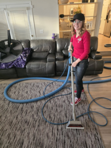 A woman actively cleaning a residential carpet with professional equipment for United Carpet Cleaning in Taylorsville, UT.