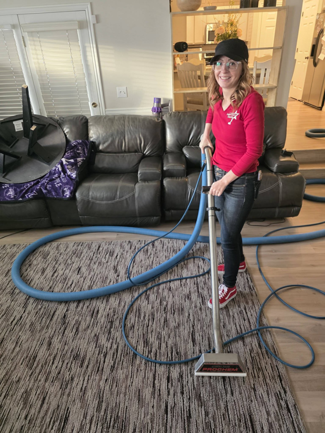 A woman actively cleaning a residential carpet with professional equipment for United Carpet Cleaning in Taylorsville, UT.