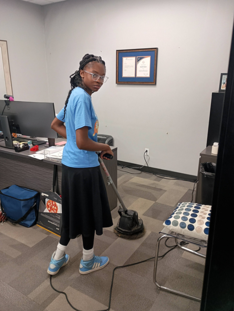 A KCclean team member cleaning office carpet with a professional machine in Arlington, TX