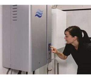 A woman operating a Condair HVAC unit, demonstrating user interaction with systems provided by Stillwell-Hansen Inc. in Edison, NJ.