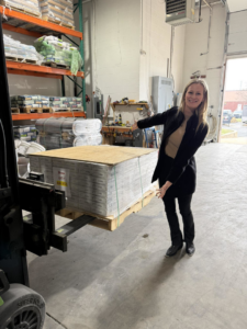 A woman with a pallet of Shaw carpet materials at Network Flooring & Maintenance in Wilmington, DE