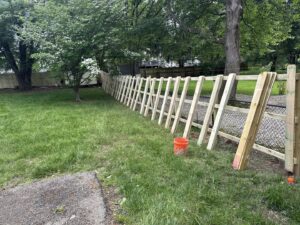 A wood and chain link fence installation in progress in a backyard by KY Fencing Unlimited in Louisville, KY.