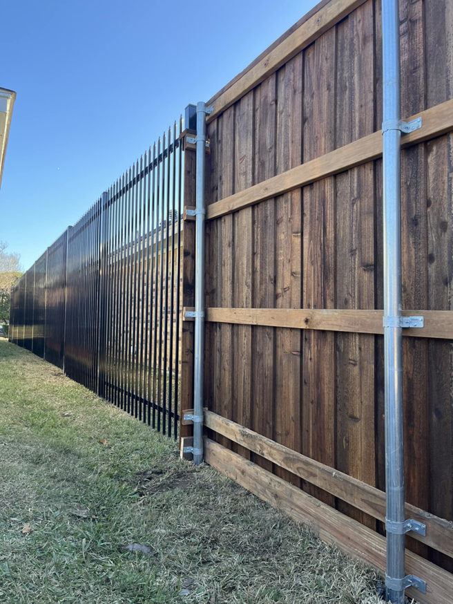 A new wood privacy fence combined with black metal picket fencing, installed by Reliable Texas Fencing in Fort Worth, TX.