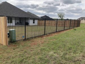 A combination wood privacy and ornamental iron fence installed by ProScape Outdoor Construction LLC in Norman, OK.