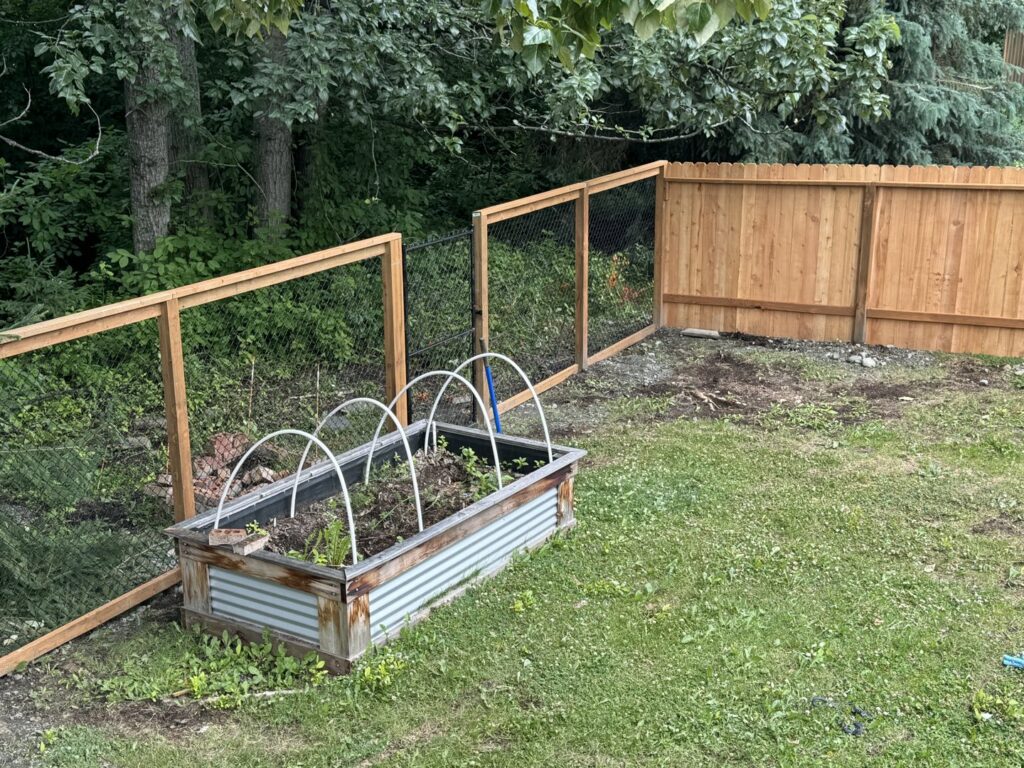 A combination wood and chain-link fence installed around a garden area, by Five Star Fence Co. in Anchorage, AK.