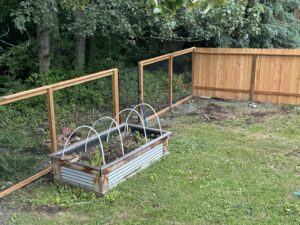 A combination wood and chain-link fence installed around a garden area, by Five Star Fence Co. in Anchorage, AK.