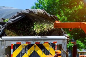 Wood chips being blown from a chipper into a truck bed for disposal by Greener Grounds Lawn and Tree in Birmingham, AL