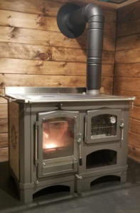 A wood cookstove with a burning fire, expertly installed by Wood Stoves For Sale in Fairbanks, AK.