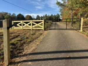A combination wood cross-buck fence and metal gate installation by Integrity Fence & Outdoor Company in Jackson, TN.
