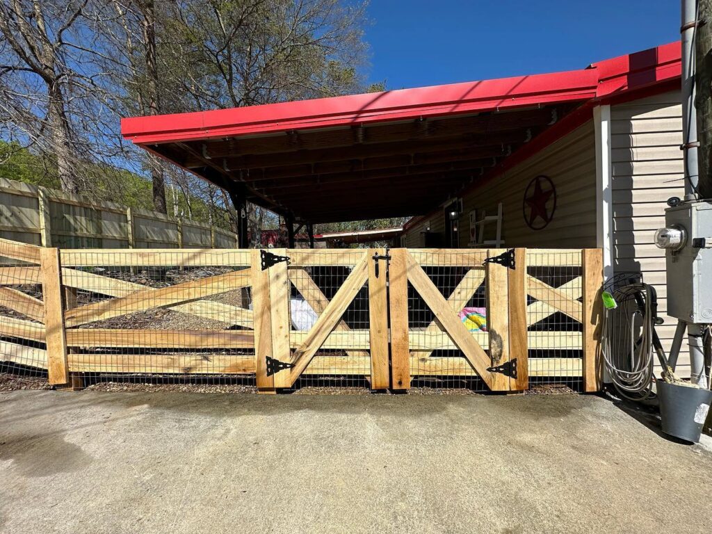 A custom-built wood cross-buck fence with wire mesh and a double gate, installed by 865 Fencing in Knoxville, TN.