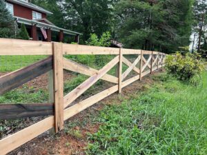 A newly installed wood cross-buck fence with wire mesh running alongside a road, built by 865 Fencing in Knoxville, TN.