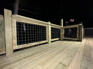 A custom-built wooden deck railing with wire mesh infill, installed by 865 Fencing in Knoxville, TN.