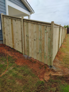 A wood privacy fence installed along a house on a slope by Maine Wood Fencing & more in Greenville, SC.