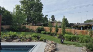 A wood fence installed around a beautifully landscaped pool area by Fencing Company Of Omaha in Omaha, NE.