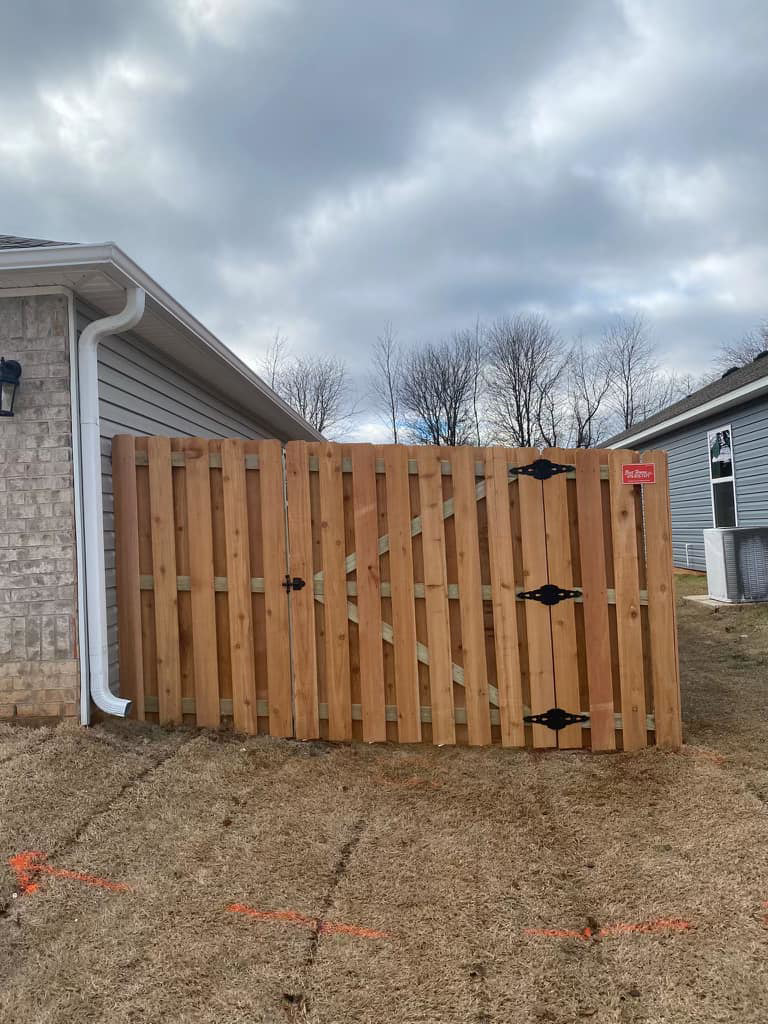A newly installed wood fence gate at the corner of a house by Best Fences LLC in Springdale, AR.
