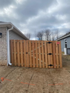 A newly installed wood fence gate at the corner of a house by Best Fences LLC in Springdale, AR.