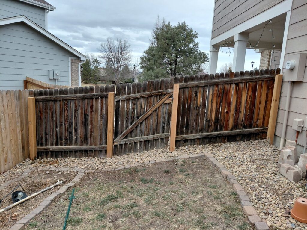 An old wood fence with a gate that has been repaired and reinforced with new posts by Done Wright Fencing and Welding in Denver, CO.