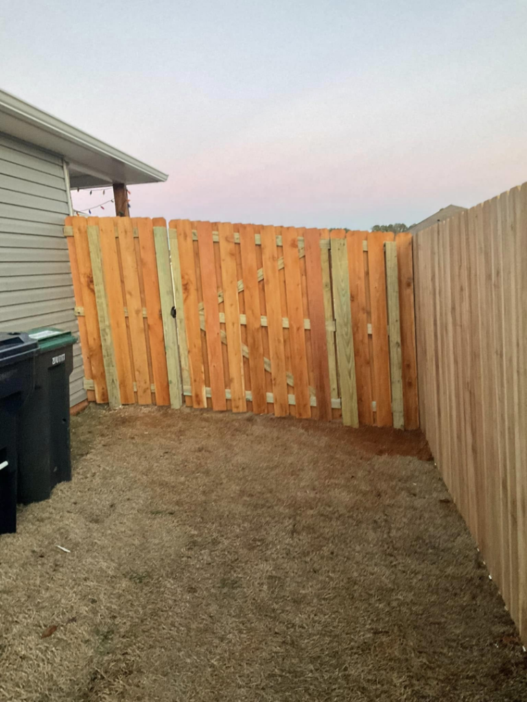 A newly installed wood fence gate in a residential side yard by Best Fences LLC in Springdale, AR.