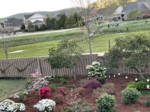 A wooden fence bordering a beautifully landscaped backyard by Alabama's Fencing in Huntsville, AL.