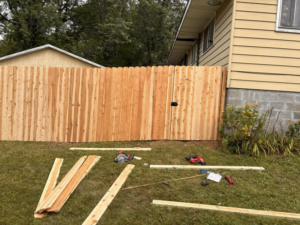 Wood fence installation in progress with tools and lumber on the ground by 218 Fencing in Duluth, MN.