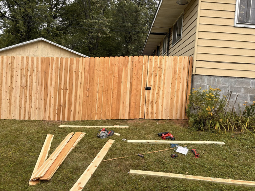 Wood fence installation in progress with tools and lumber on the ground by 218 Fencing in Duluth, MN.