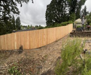 A new wood fence installation expertly following the contours of a sloped backyard by RPB Fence in Salem, OR