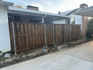 A sturdy wood fence with metal posts and a gate, demonstrating quality craftsmanship by NTX-Exterior Services in Dallas, TX.