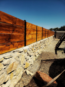 A newly installed wooden fence atop a stone retaining wall by Las Cruces Fencing in Las Cruces, NM.