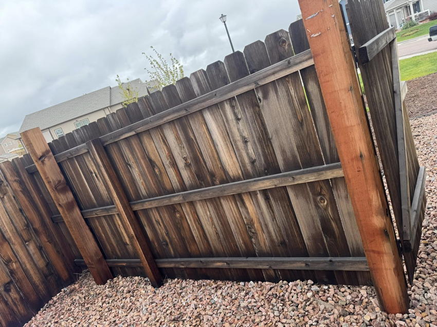 The back side of a wooden fence showing new support posts installed for repair by Slater Fence Co in Houston, TX.
